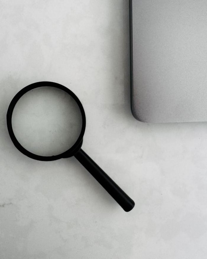 Lupa junto a un portátil, referencia visual de una auditoría SEO