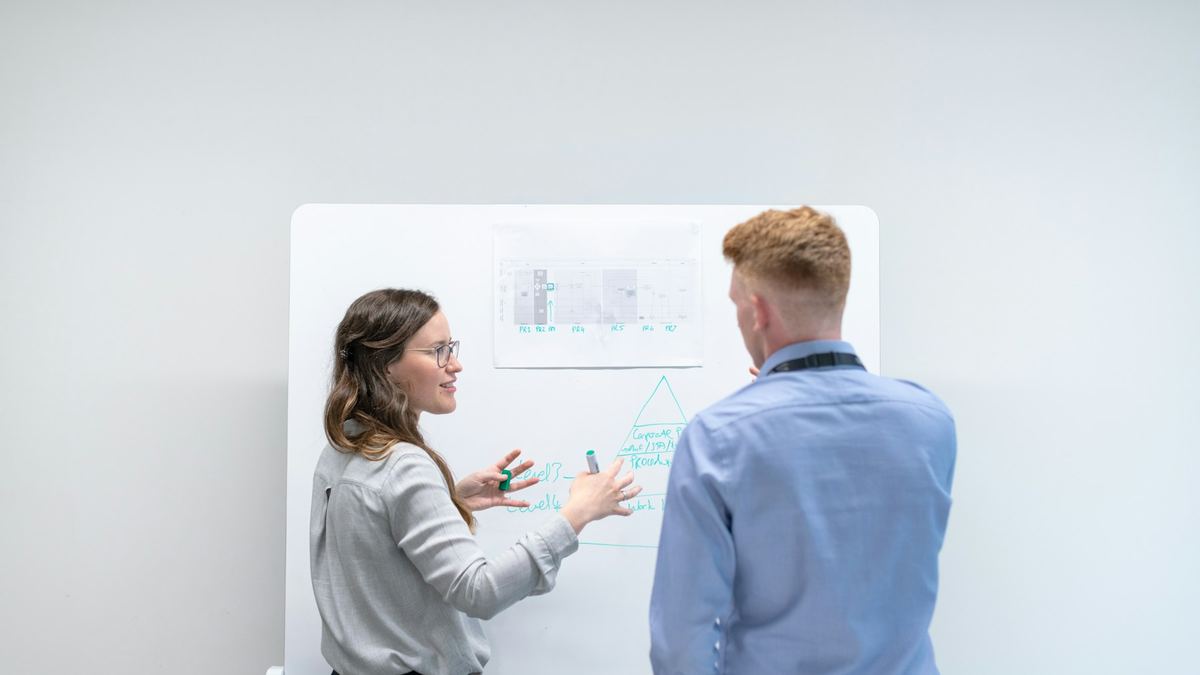 Dos profesionales definiendo la estrategia digital en una pizarra